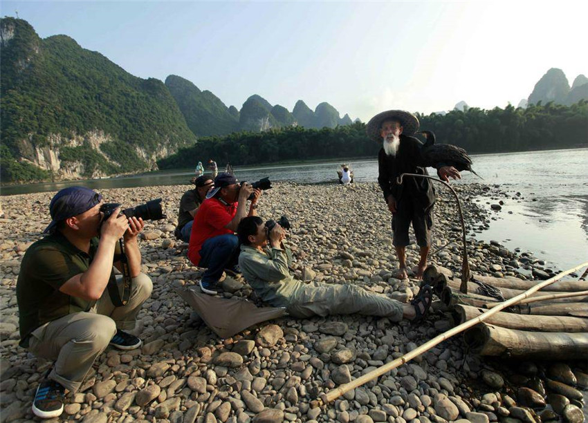 Greise Brüder modeln als Fischer auf dem Li-Fluss