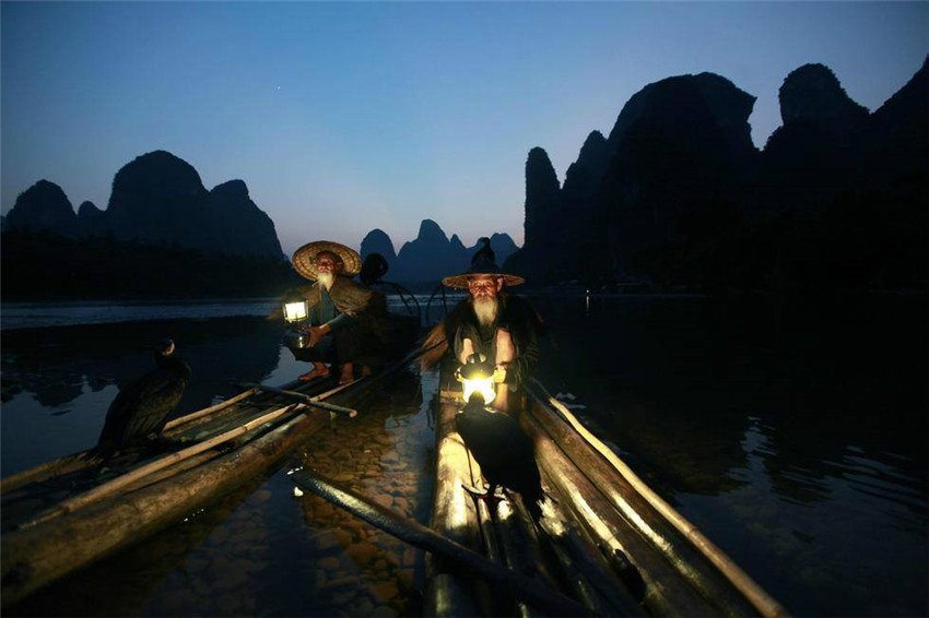 Greise Brüder modeln als Fischer auf dem Li-Fluss