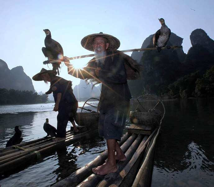 Greise Brüder modeln als Fischer auf dem Li-Fluss